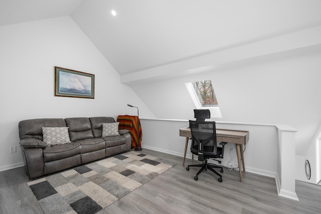 office space featuring baseboards, wood finished floors, and lofted ceiling with skylight