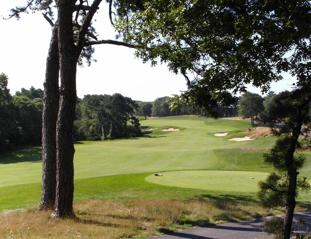 surrounding community with view of golf course and a yard