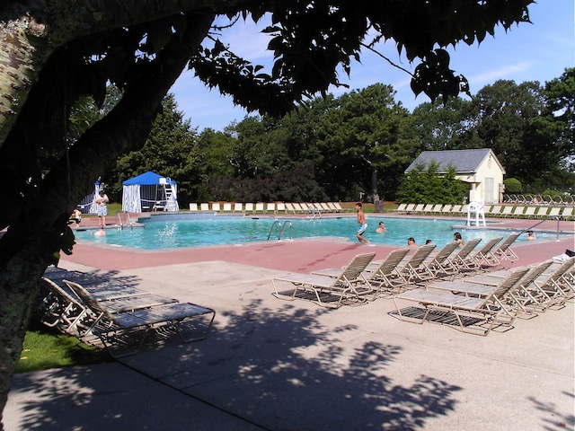 pool with an outdoor structure and a patio
