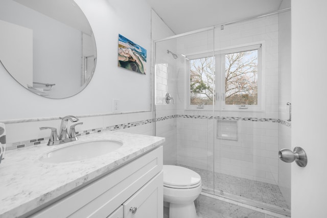 full bath featuring toilet, a stall shower, and vanity