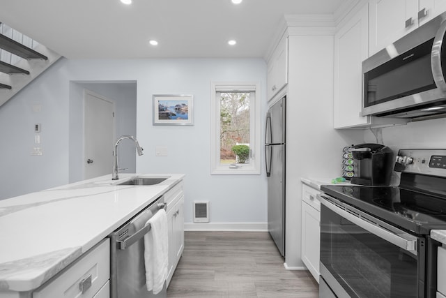 kitchen featuring white cabinetry, recessed lighting, a sink, visible vents, and appliances with stainless steel finishes