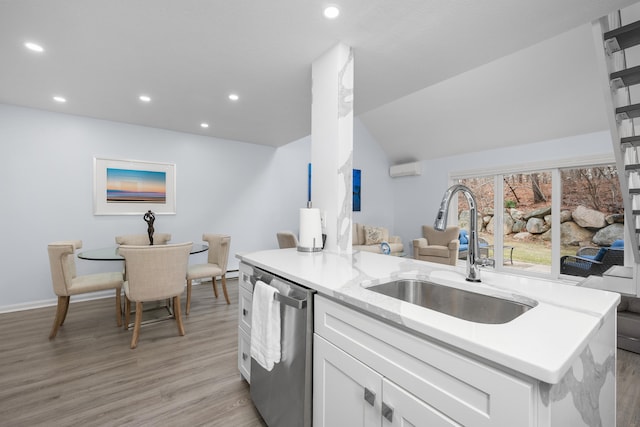 kitchen with white cabinets, light wood finished floors, recessed lighting, a sink, and stainless steel dishwasher