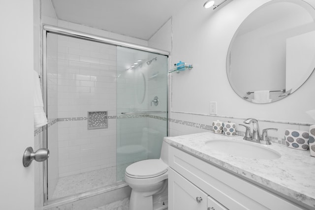 bathroom featuring a stall shower, toilet, and vanity