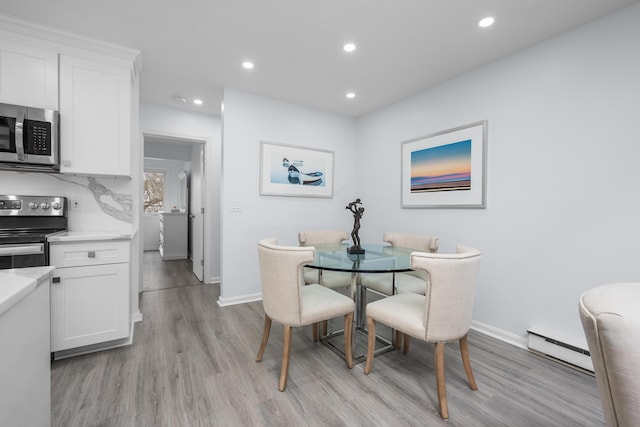dining room featuring baseboard heating, light wood-style flooring, and recessed lighting
