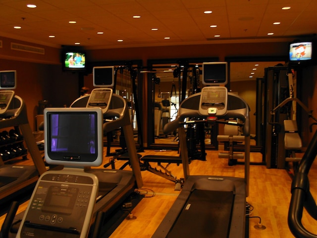 exercise room featuring wood finished floors and recessed lighting