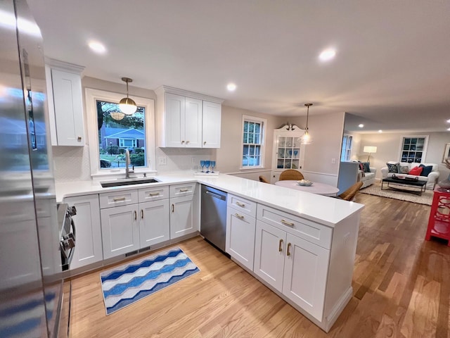 40 Highland Dr, Centerville, MA 02632 - kitchen with dishwasher, freestanding refrigerator, a peninsula, light wood-style floors, and light countertops