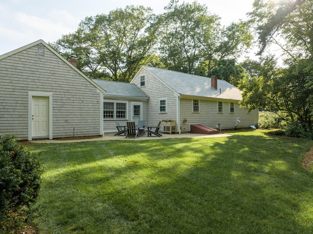 40 Highland Dr, Centerville, MA 02632 - back of house featuring a chimney, a patio, and a lawn
