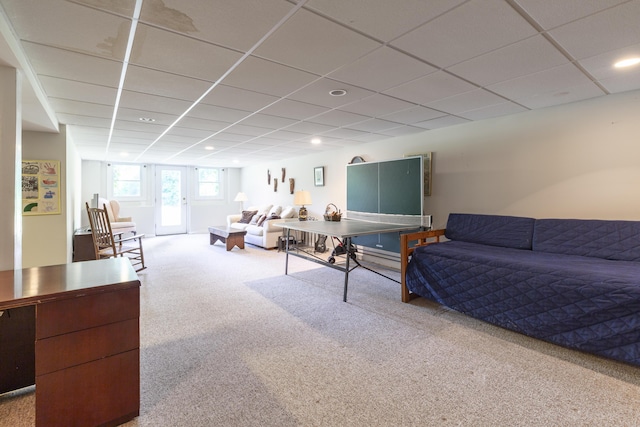 living room featuring carpet and a drop ceiling