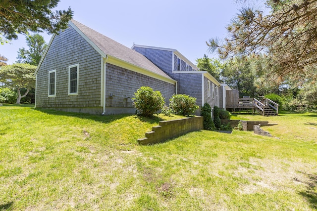 view of home's exterior featuring a wooden deck and a lawn