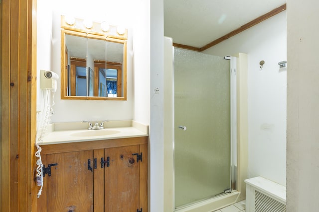 bathroom featuring vanity, crown molding, a shower with door, and tile patterned flooring