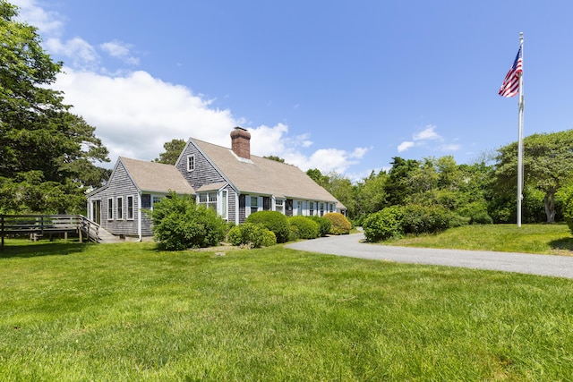 cape cod house with a front lawn