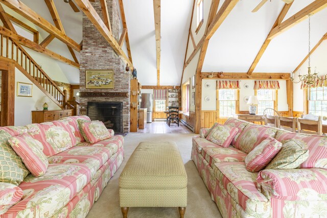 carpeted living room with an inviting chandelier, beamed ceiling, high vaulted ceiling, and a healthy amount of sunlight