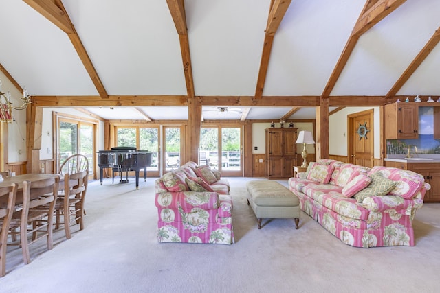 living room with high vaulted ceiling, light colored carpet, and beamed ceiling