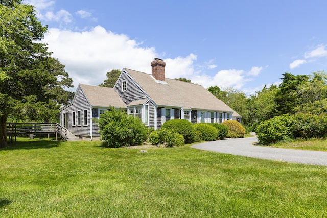 cape cod-style house featuring a front yard