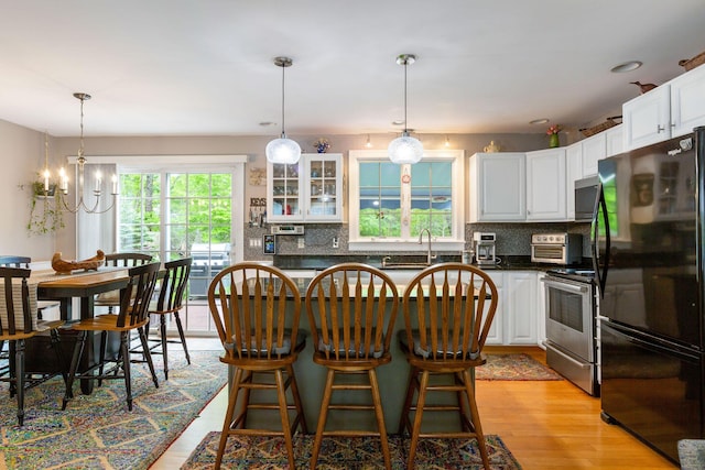 33 Rogers Rd, Brewster, MA 02631 - kitchen featuring freestanding refrigerator, stainless steel range with electric cooktop, white cabinetry, and backsplash