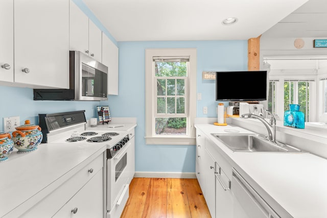 kitchen with sink, dishwasher, white range with electric cooktop, a wealth of natural light, and white cabinets