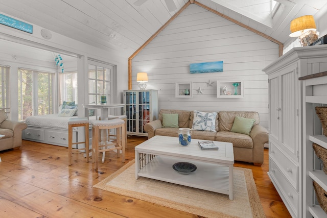 living room featuring hardwood / wood-style flooring and vaulted ceiling with skylight