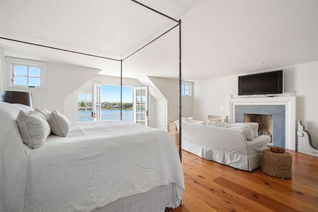 23 Oyster Pond Ln, Chatham, MA 02633 - bedroom with wood-type flooring, multiple windows, and a fireplace