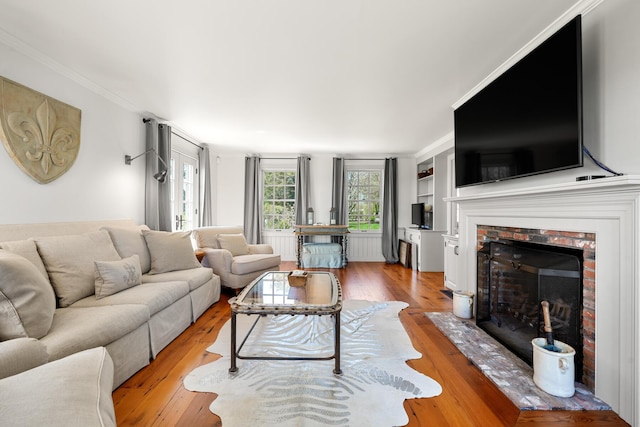 23 Oyster Pond Ln, Chatham, MA 02633 - living area with a brick fireplace, light wood finished floors, and crown molding