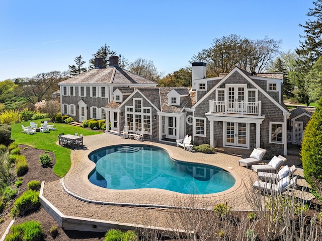 23 Oyster Pond Ln, Chatham, MA 02633 - rear view of property featuring french doors, a patio area, a chimney, a yard, and an outdoor pool