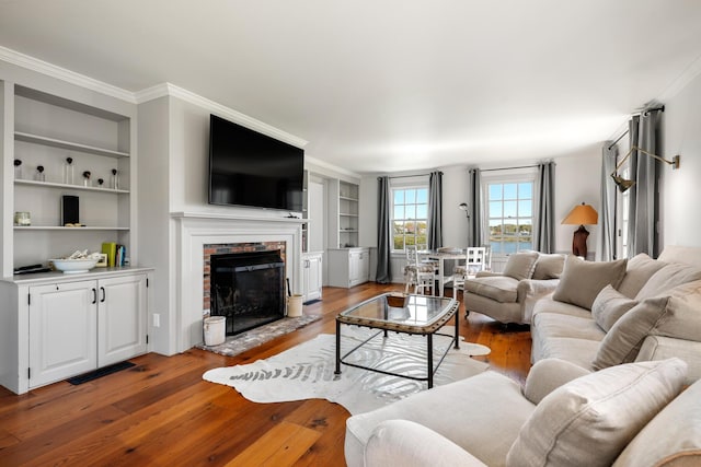 23 Oyster Pond Ln, Chatham, MA 02633 - living room featuring light wood-type flooring, built in features, a fireplace, and crown molding