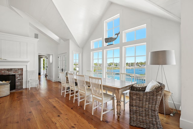 23 Oyster Pond Ln, Chatham, MA 02633 - dining area featuring high vaulted ceiling, wood-type flooring, a water view, and a fireplace