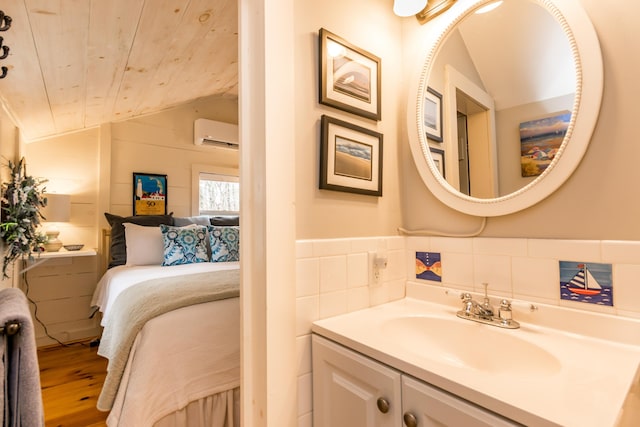 bathroom with a wall unit AC, vaulted ceiling, wood finished floors, vanity, and wooden ceiling