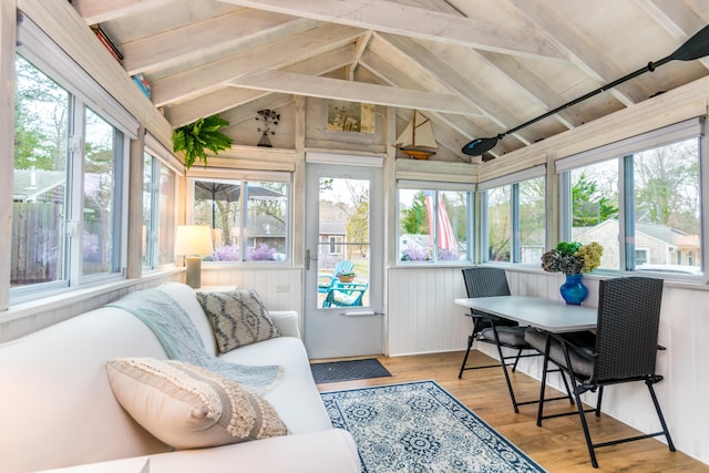 sunroom / solarium featuring a deck, wood finished floors, and lofted ceiling