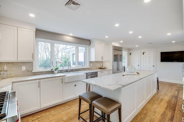 kitchen featuring a sink, decorative backsplash, white cabinets, and appliances with stainless steel finishes