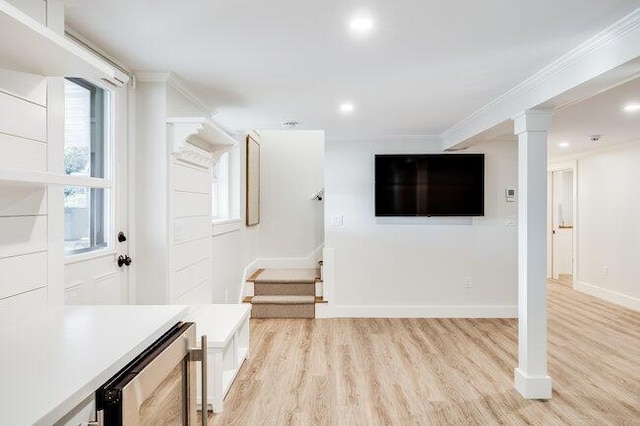 unfurnished living room with wine cooler, recessed lighting, crown molding, and light wood-type flooring