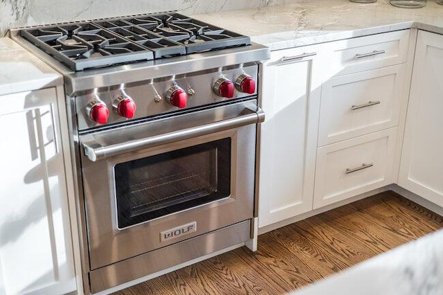 details with designer range, light countertops, and white cabinets