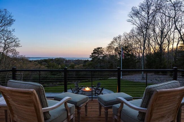 view of wooden balcony featuring a wooden deck and a fire pit