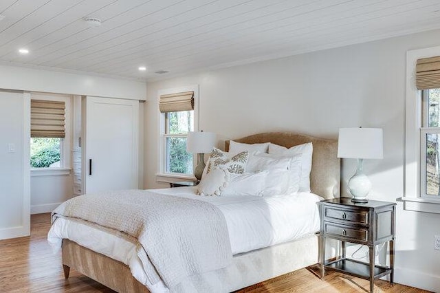 bedroom with multiple windows, wood finished floors, and recessed lighting