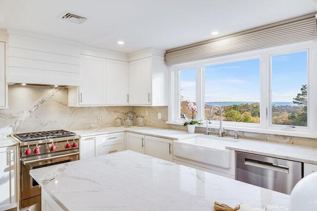 kitchen featuring a sink, stainless steel appliances, tasteful backsplash, visible vents, and white cabinets