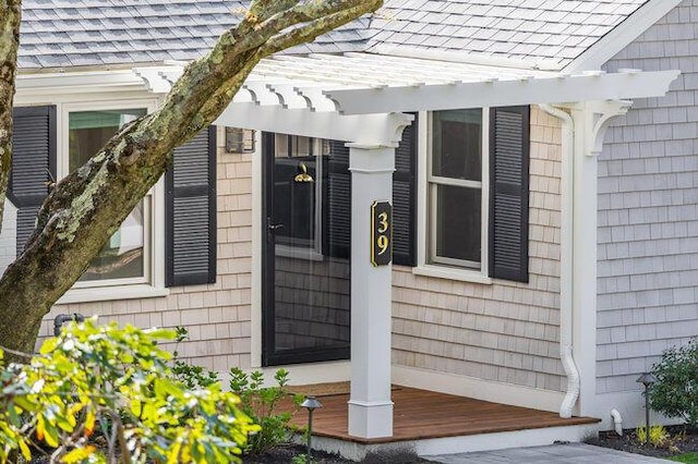 view of home's exterior featuring a pergola and roof with shingles