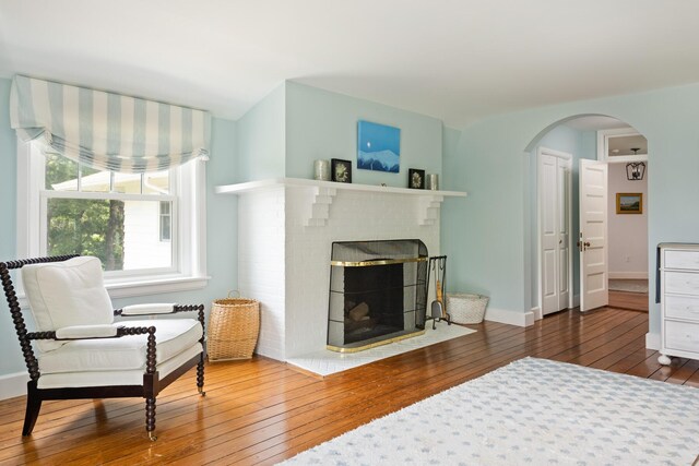 150 Sea View Ave, Osterville, MA 02655 - living room with baseboards, a fireplace, arched walkways, and wood-type flooring