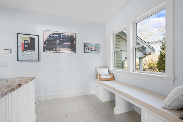 living area featuring light tile patterned floors and baseboards