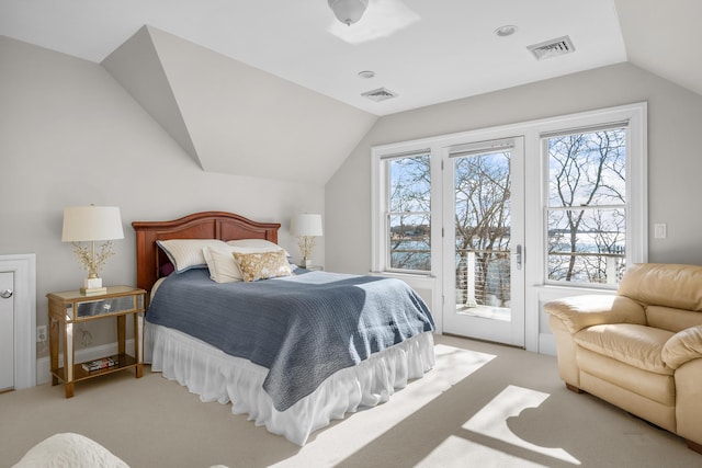 bedroom featuring access to exterior, lofted ceiling, visible vents, and multiple windows