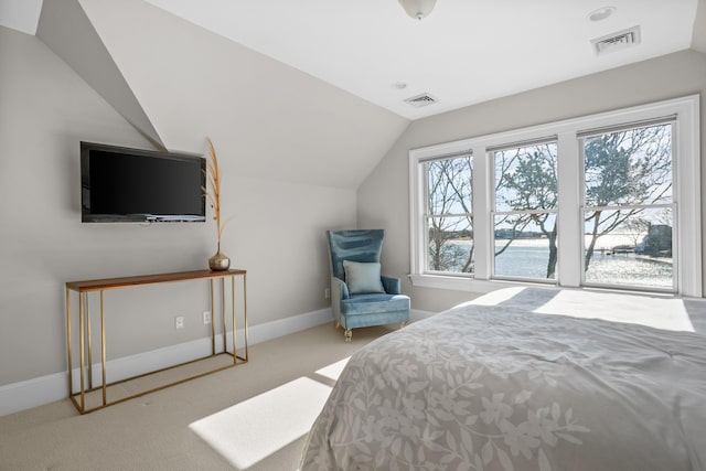 carpeted bedroom featuring a water view, visible vents, and vaulted ceiling