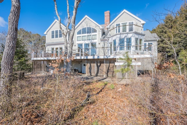 back of property featuring a chimney and a deck