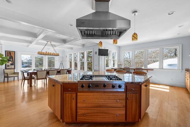 kitchen with brown cabinets, stainless steel gas cooktop, extractor fan, and hanging light fixtures