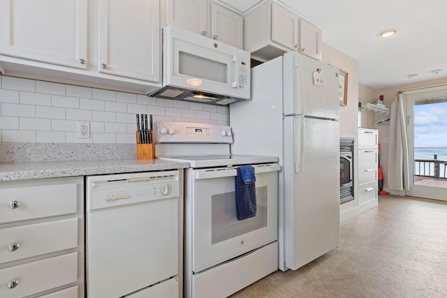 496 Shore Rd Unit 4, Truro, MA 02666 - kitchen with white appliances, light flooring, decorative backsplash, recessed lighting, and light stone countertops