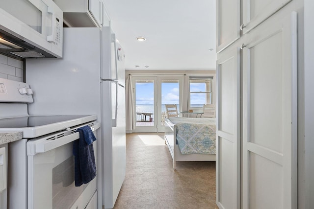 496 Shore Rd Unit 4, Truro, MA 02666 - kitchen with white appliances, light colored carpet, light countertops, french doors, and backsplash