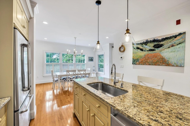 780 Craigville Beach Rd Unit 10, Centerville, MA 02632 - kitchen with appliances with stainless steel finishes, cream cabinetry, ornamental molding, light wood-style flooring, and decorative light fixtures
