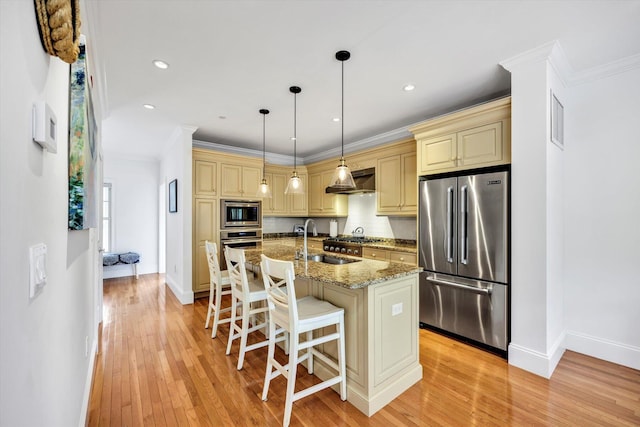 780 Craigville Beach Rd Unit 10, Centerville, MA 02632 - kitchen featuring appliances with stainless steel finishes, cream cabinetry, exhaust hood, light wood-style floors, and a breakfast bar