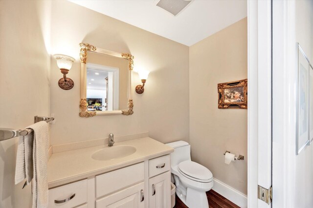 86 Summersea Rd, Mashpee, MA 02649 - half bath with vanity, toilet, visible vents, baseboards, and wood finished floors