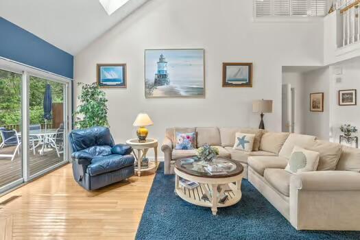 3 Mayfair Ct, Mashpee, MA 02649 - living room featuring high vaulted ceiling, a skylight, and wood finished floors