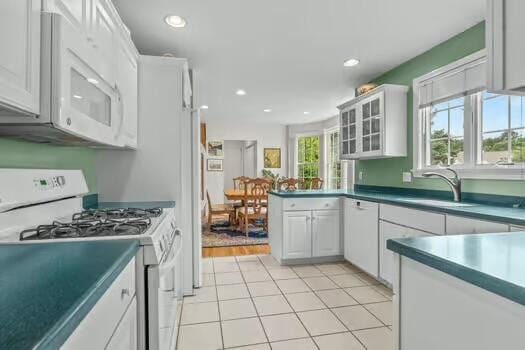 3 Mayfair Ct, Mashpee, MA 02649 - kitchen with white appliances, a peninsula, glass insert cabinets, recessed lighting, and light tile patterned flooring