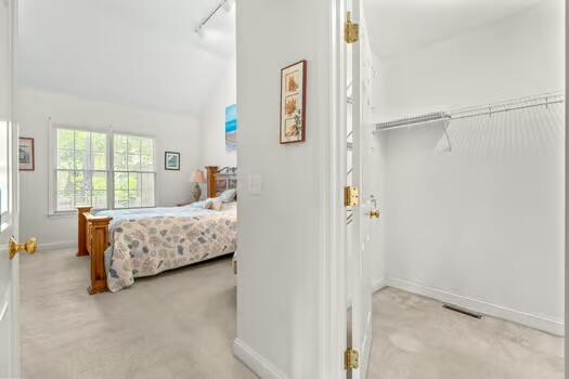 3 Mayfair Ct, Mashpee, MA 02649 - carpeted bedroom with lofted ceiling and track lighting