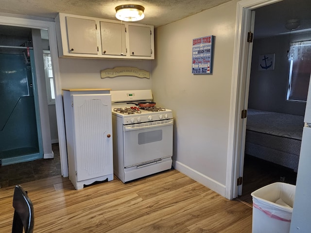 kitchen featuring white gas range oven and light hardwood / wood-style floors